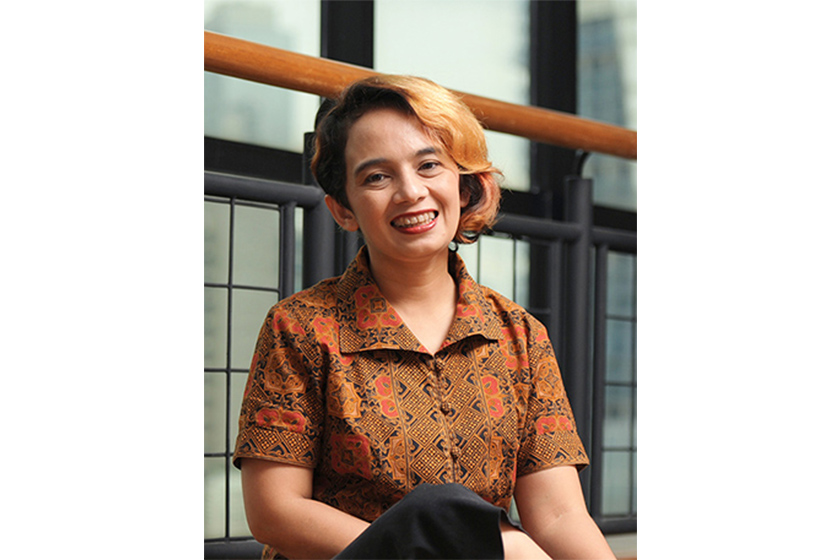A woman wearing batik shirt smiling